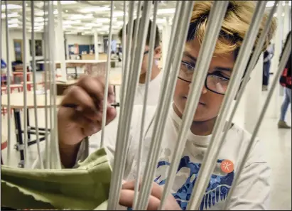  ??  ?? Arnav Patil, 12, pulls fabric through a loom for the Invent the Future Challenge.