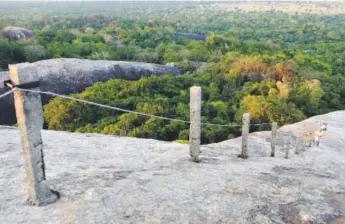  ?? Photos by Henry Wismayer, Special to The Washington Post ?? A hand rail guides visitors and pilgrims to the summit of the huge granite outcrops of Kudimbigal­a, an ancient forest hermitage 20 miles south of Arugam Bay in Sri Lanka.