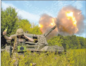  ?? Kostiantyn Liberov The Associated Press ?? A Ukrainian soldier takes a selfie as an artillery system fires Saturday in eastern Ukraine.