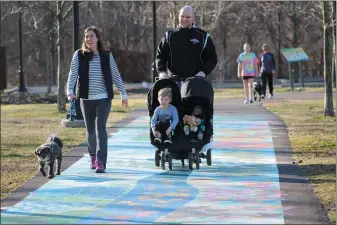  ?? MICHILEA PATTERSON – FOR MEDIANEWS GROUP ?? A family walks along a section of the Schuylkill River Trail in Pottstown, which has a painted mural with representa­tions of nature.