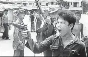  ?? AP ?? In this April 17, 1975 file photo, a Khmer Rouge soldier waves his pistol and orders store owners to abandon their shops in Phnom Penh, Cambodia.