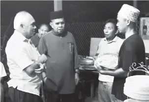  ??  ?? MESRA: Pengerusi penganjur, Abdullah Pungut (dua kiri) beramah mesra bersama Yusof dan pengunjung majlis kenduri kesyukuran dan ibadah korban di Kampung Batu 7 Pantai Sipitang.