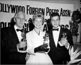  ?? THE ASSOCIATED PRESS ?? Actress Doris Day, center, Tony Curtis, right, and Buddy Adler pose with their awards presented to them by the Hollywood Foreign Press Associatio­n at its annual awards dinner in the Cocoanut Grove in Los Angeles. Day, whose wholesome screen presence stood for a time of innocence in ‘60s films, has died, her foundation says. She was 97.