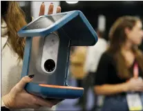  ?? JOHN LOCHER — THE ASSOCIATED PRESS ?? An exhibitor holds up the Bird Buddy smart camera bird feeder during CES 2023. The AI-powered feeder notifies you when a bird is feeding, takes pictures and organizes the photos.