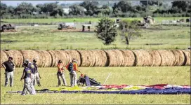  ?? TAMIR KALIFA / FOR NEW YORK TIMES ?? Authoritie­s examine balloon debris July 30 in a field near Lockhart. Weather conditions at the time of the crash included clouds and fog.