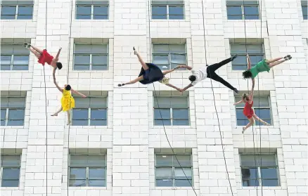  ??  ?? Dancers from the Bandaloop aerial dance troupe perform to a medley of songs from La La Land off to the side of Los Angeles City Hall.