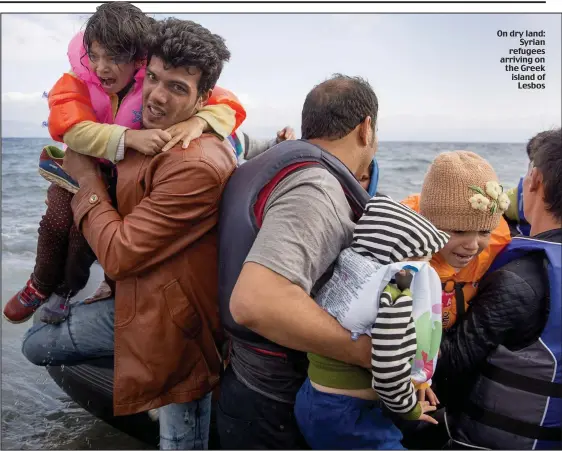  ??  ?? On dry land:
Syrian refugees arriving on the Greek island of
Lesbos