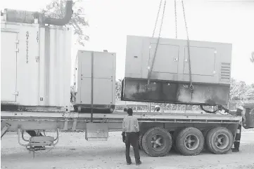  ??  ?? Electricit­y generators being removed from the compounds at the Manus Island detention centre in PNG. — Reuters photos