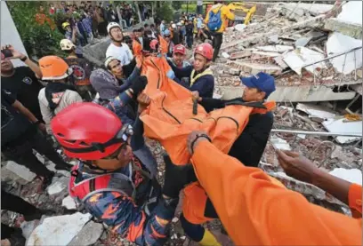  ?? ?? Rescue workers carry the body of a victim in Cianjur on Tuesday, following a 5.6-magnitude earthquake that killed at least 162 people, with hundreds injured and others missing.