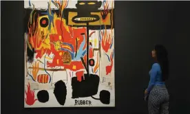  ??  ?? A Sotheby’s employee looks at genuine Jean-Michel Basquiat painting, titled Rubber, during a sale in London. Photograph: Frank Augstein/AP