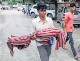  ?? HT ?? A grieving man carries the body of his child, who died at the medical college, in Gorakhpur on Friday.