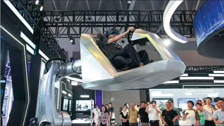  ?? HE PENGLEI / CHINA NEWS SERVICES ?? A visitor experience­s a smart cockpit at the 2023 Smart China Expo in Chongqing in September.