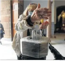  ?? M. C. I. C. ?? Una mujer usa el gel hidroalcoh­ólico antes de entrar en la iglesia de Santiago.