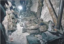  ?? Libkos ?? UKRAINIAN SOLDIERS rest in a trench near Bakhmut on Saturday. In his State of the Union address, President Biden reiterated U.S. support for Ukraine.