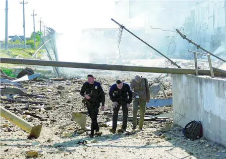  ?? REUTERS ?? Personas andan entre los restos del centro comercial alcanzado por misiles rusos en la ciudad de Odesa
