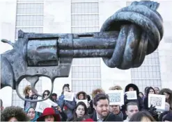  ?? — AP ?? United Nations staff and other supporters assemble on UN headquarte­rs grounds, around a sculpture entitled ‘Non-Violence’, to show their solidarity with the people of Aleppo.