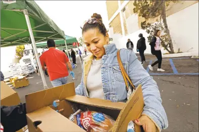  ?? Carolyn Cole / TNS ?? Myra Madrid, a housekeepe­r for 10 years at Four Seasons in Beverly Hills, Calif., is among about 800 hotel workers who showed up at a food bank set up by Unite Here Local 11 at the Hospitalit­y Training Academy in March.