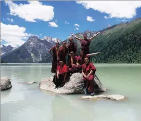  ?? Pictures: JIEMING SUN ?? CULTURAL EXPLORATIO­N: Manigange Lake, Sichuan, China, with some local monks. Jieming was inspired to live his life for himself and explore instead of living by society’s expectatio­ns.
