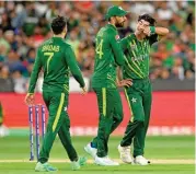  ?? (AFP) ?? Pakistan’s Shadab Khan and Shan Masood (C) encourage team-mate Naseem Shah during the final against England on Sunday