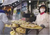  ??  ?? Dumplings are displayed outside a restaurant in a market in Seoul. The government reimposed strict distancing rules on Seoul and surroundin­g regions this week as it battles a surge in virus cases.