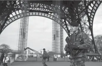  ?? JOEL SAGET/AFP/GETTY IMAGES ?? Soldiers patrol under the Eiffel Tower earlier this week in Paris after Islamist militants issued threats.