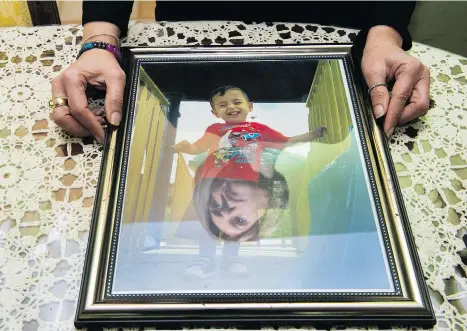  ?? ARLEN REDEKOP ?? Tima Kurdi’s face is reflected in a photo of her nephew Alan. The Coquitlam woman has written a memoir about her family’s fateful attempt to escape from Syria. Another photo of little Alan’s body washed up on the beach became a rallying cry for the...