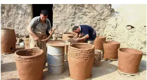  ?? — AFP ?? Ancient craft: Iraqis making clay pots in Najaf.
