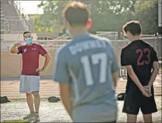  ??  ?? A MASKED Mires speaks to his team before practice. Three years ago, 13 Downey boys’ soccer players went on to four- year colleges.