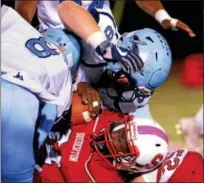  ?? BOB RAINES — DIGITAL FIRST MEDIA ?? North Penn’s Shamar Edwards and Owen Verespy tumble Souderton runner Deandre Wakefield over a pile of his own teammates Friday night.