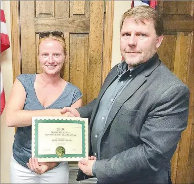  ?? Submitted Photo ?? Gravette Mayor Kurt Maddox shakes Rebecca Zito’s hand as she displays the business license for Highlands Storage, located at 13842 Highway 279 in Hiwasse. Rebecca and her husband own the newly opened business which offers storage units for boats and RVs. Maddox was welcoming them to the local business community.