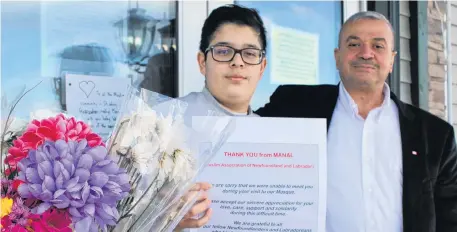  ?? BARB SWEET THE TELEGRAM ?? Moein Shahwan, right, and his son, Abdullah, take comfort in the outpouring of support from the public after last week’s devastatin­g attack in New Zealand. People have been leaving flowers and other mementos in front of the St. John’s mosque.•