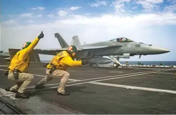  ?? SPECIALIST 3RD CLASS JEFF SHERMAN, U.S. NAVY VIA AP ?? Navy officers launch an F-18 Super Hornet from the flight deck of the USS Abraham Lincoln aircraft carrier on Thursday in the Arabian Sea.