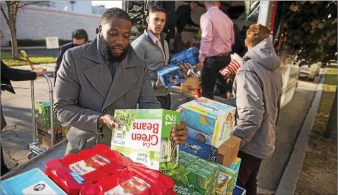  ?? RICK KAUFFMAN — DIGITAL FIRST MEDIA ?? Ty Simmons, left, Jacques Cooper, center, and Gordon McDonough, right, were among the more than a dozen employees in inside sales at POWER Home Remodeling who helped deliver a shipment of supplies to the Wesley House in Chester.