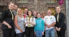  ??  ?? Serena Pierce (holding trophies) and her coach and dad, Tony celebrate her recent world title wins in Matla with the sponsors and sponsor organisers and staff members from the Auld Triangle, Shauna & Micheala, where it all started. Photo: John Delea