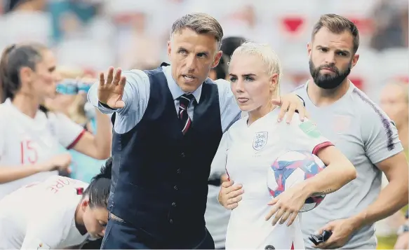  ??  ?? England head coach Phil Neville gives instructio­ns to Alex Greenwood.