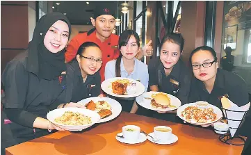  ??  ?? Tony Roma’s staff at its Vivacity Megamall outlet showing some of the set lunch dishes.