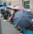  ??  ?? Journalist­en warteten im Regen vor dem Gerichtsge­bäude darauf, dass es losgeht.