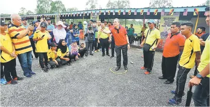  ??  ?? RASMI: Fadillah ketika menyempurn­akan simbolik perasmian Kejohanan Petanque Beregu NSIX Tupong Piala Datuk Seri Fadillah Yusof di Kuching semalam.