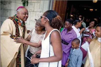  ?? The Associated Press ?? ARCHBISHOP: In this June 2, 2019, file photo, Archbishop of Washington Wilton Gregory, left, greets parishione­rs following Mass at St. Augustine Church in Washington. In June 2020, Gregory, the first African-American in charge of the Archdioces­e of Washington, joined with eight fellow bishops from his region to acknowledg­e the church’s “sins and failings” in regard to racial justice. “Prayer and dialogue, alone, are not enough. We must act to bring about true change,” the bishops said, calling for more racial equality in health care, education, housing and criminal justice.