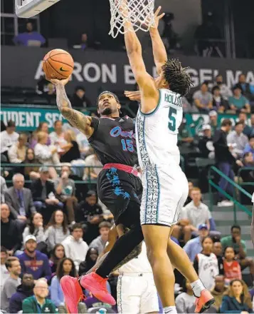  ?? TYLER KAUFMAN AP ?? Florida Atlantic guard Alijah Martin shoots against Tulane forward Collin Holloway (5) during the first half.