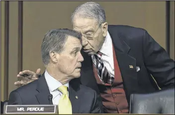  ?? SUSAN WALSH / ASSOCIATED PRESS ?? Senate Judiciary Committee Chairman Sen. Charles Grassley (right), R-Iowa, talks with Sen. David Perdue, R-Ga., as attorney general nominee Loretta Lynch testifies in January before the committee’s hearing on her nomination.
