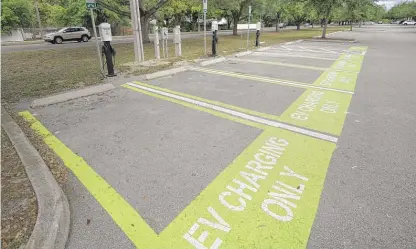  ?? JOHN RAOUX/AP ?? A parking area with charging stations for electric vehicles at a park last Thursday in Orlando, Florida.