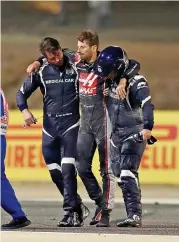  ??  ?? Stewards and medics attend to Haas’ French driver Romain Grosjean (centre) after a crash at the start of the Bahrain Formula One Grand Prix