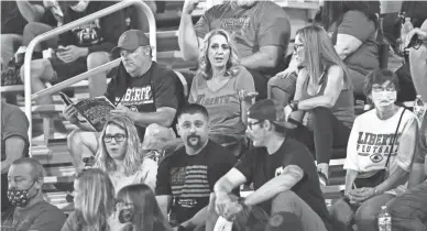  ?? ROB SCHUMACHER/THE REPUBLIC ?? Several spectators sit in the stands without masks at a football game at Liberty Hill School.