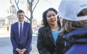  ??  ?? Colfax and Breed speak to someone on the street on their way to the fair where Colfax surveyed the scene and spoke with city health workers.