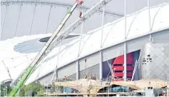  ?? - AFP photo ?? Labourers undertake restoratio­n work at Doha’s Khalifa Internatio­nal Stadium .