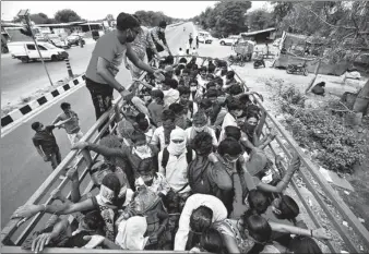  ?? AMIT DAVE / REUTERS ?? Migrant workers and their families board a truck in Ahmedabad, India on Wednesday to return to their villages after the country ordered a 21-day nationwide lockdown.