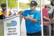  ?? AP PHOTO/LYNNE SLADKY ?? An election worker stamps a vote-by-mail ballot dropped off by a voter before placing it in an official ballot drop box before at the Miami-Dade County Board of Elections on Oct. 26 in Doral, Fla.