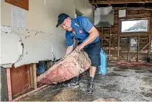  ?? BRADEN FASTIER/NELSON MAIL ?? Steve Clifton of Jae Services removes insulation from the walls of a flood-affected home in Ruby Bay, Tasman.