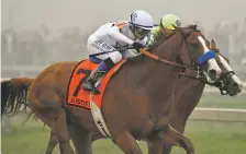  ?? TOM HORAN ASSOCIATED PRESS ?? Justify, with Mike Smith aboard, runs against Good Magic, with Jose Ortiz atop, in the final stretch of the 143rd Preakness Stakes on Saturday at Pimlico race track in Baltimore. Justify won by half a length.